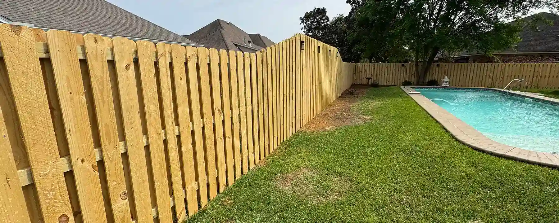 Backyard shadowbox wood fence surrounding a pool in Mobile Alabama